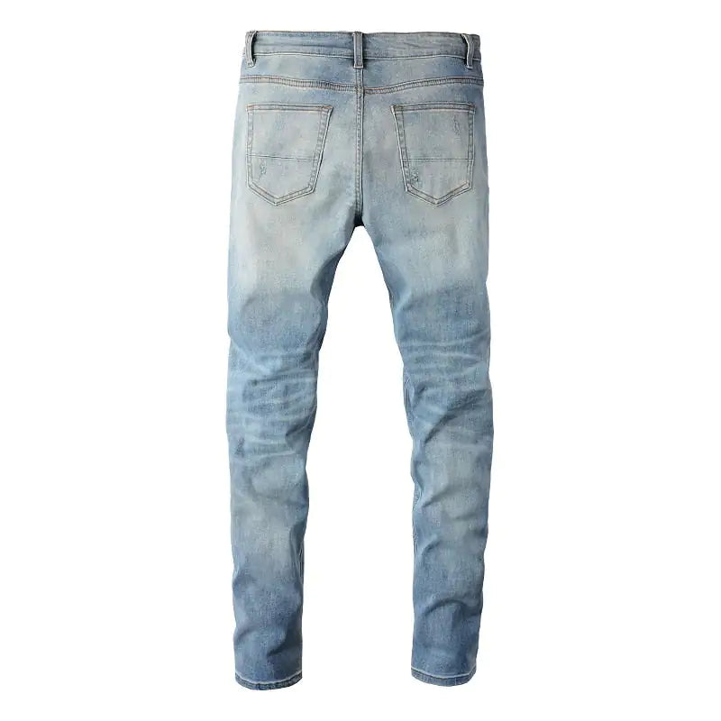 Distressed light blue denim jeans with rips and wear for a trendy, casual look.